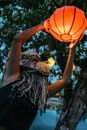 Woman in Black Dress Holding Orange Lantern