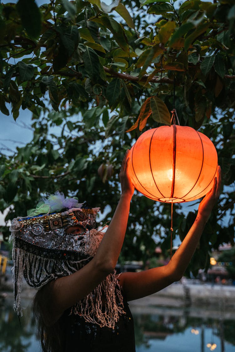 A Person Holding And Illuminated Lantern