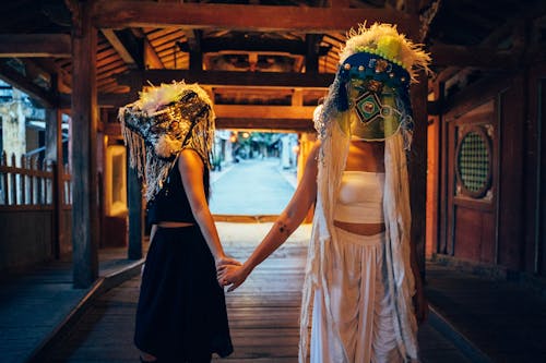 Two Persons Holding Hands while Wearing a Mask