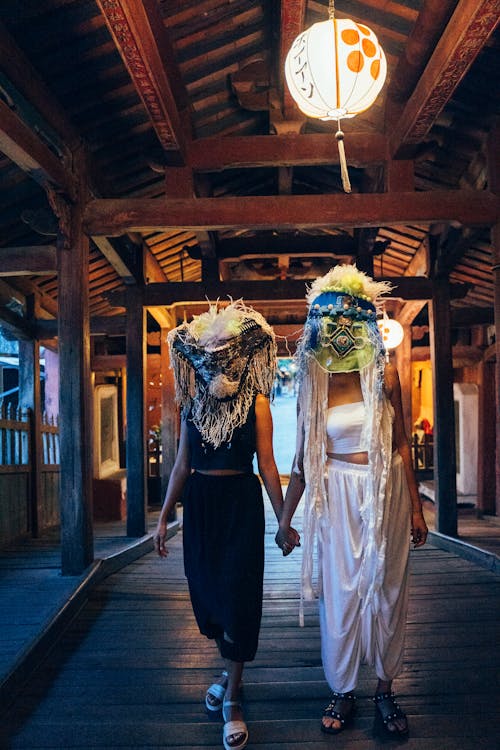 Two Persons Holding Hands while Standing Under the Lantern