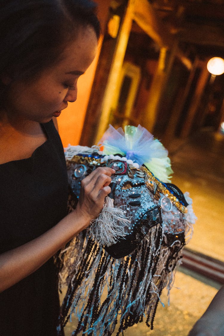 A Woman In Black Shirt Holding A Mask