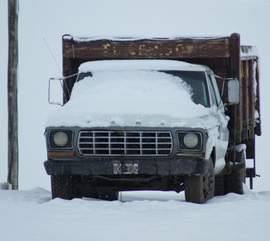 A vintage Ford truck parked in snowy conditions in rural Argentina, creating a nostalgic winter scene.