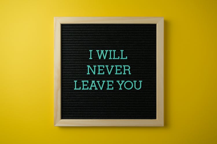 Heartwarming Sign On Black Board Hanging On Yellow Wall