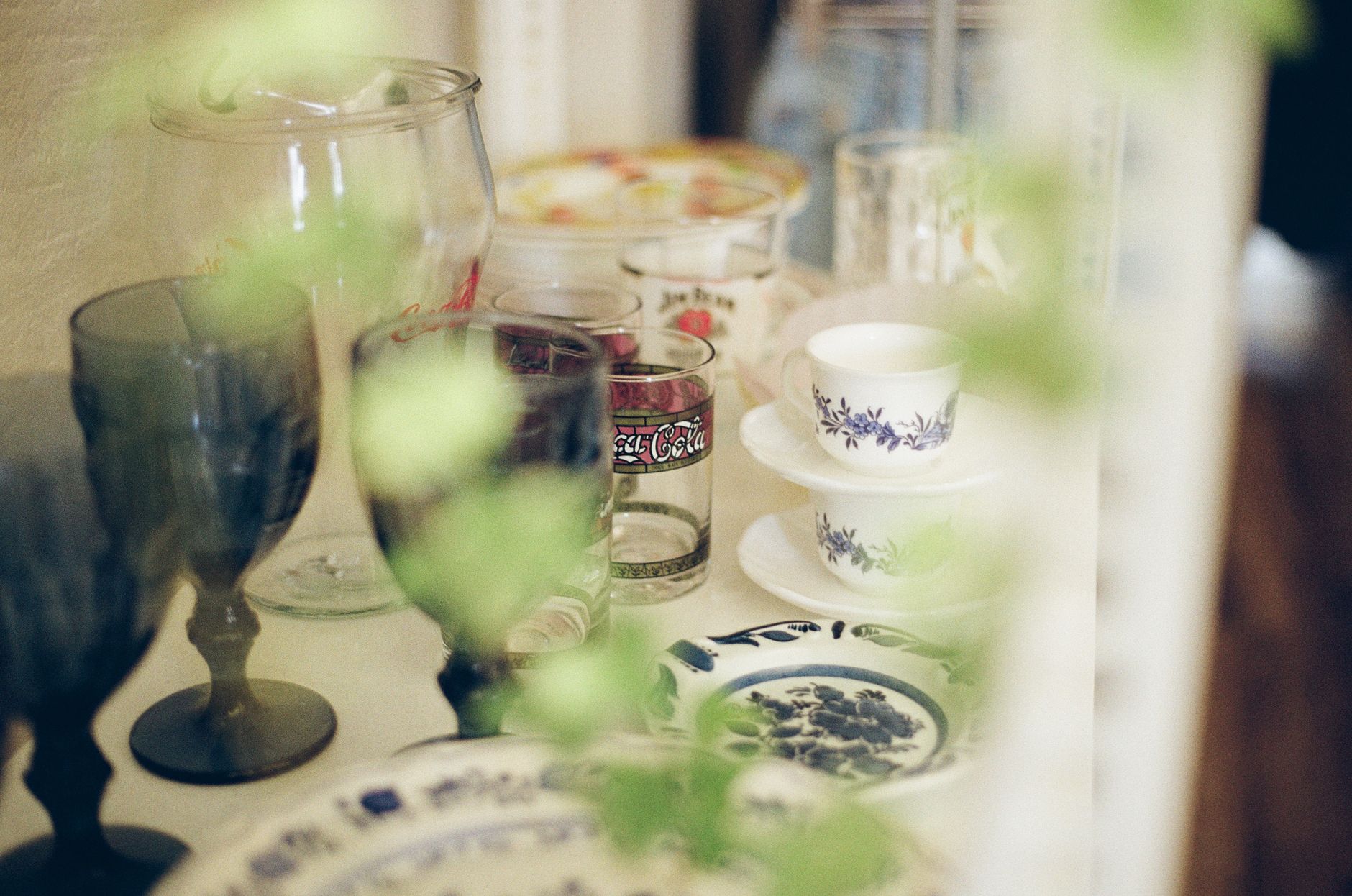Charming close-up of vintage glassware and plates on display in Ho Chi Minh City, Vietnam.