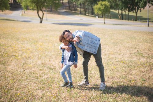 Free Father and son enjoy a sunny day in a Portugal park, embracing and smiling. Stock Photo