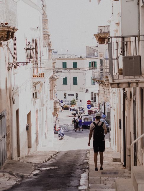 Explore the charm of a Mediterranean street with historic facades and a lone traveler.