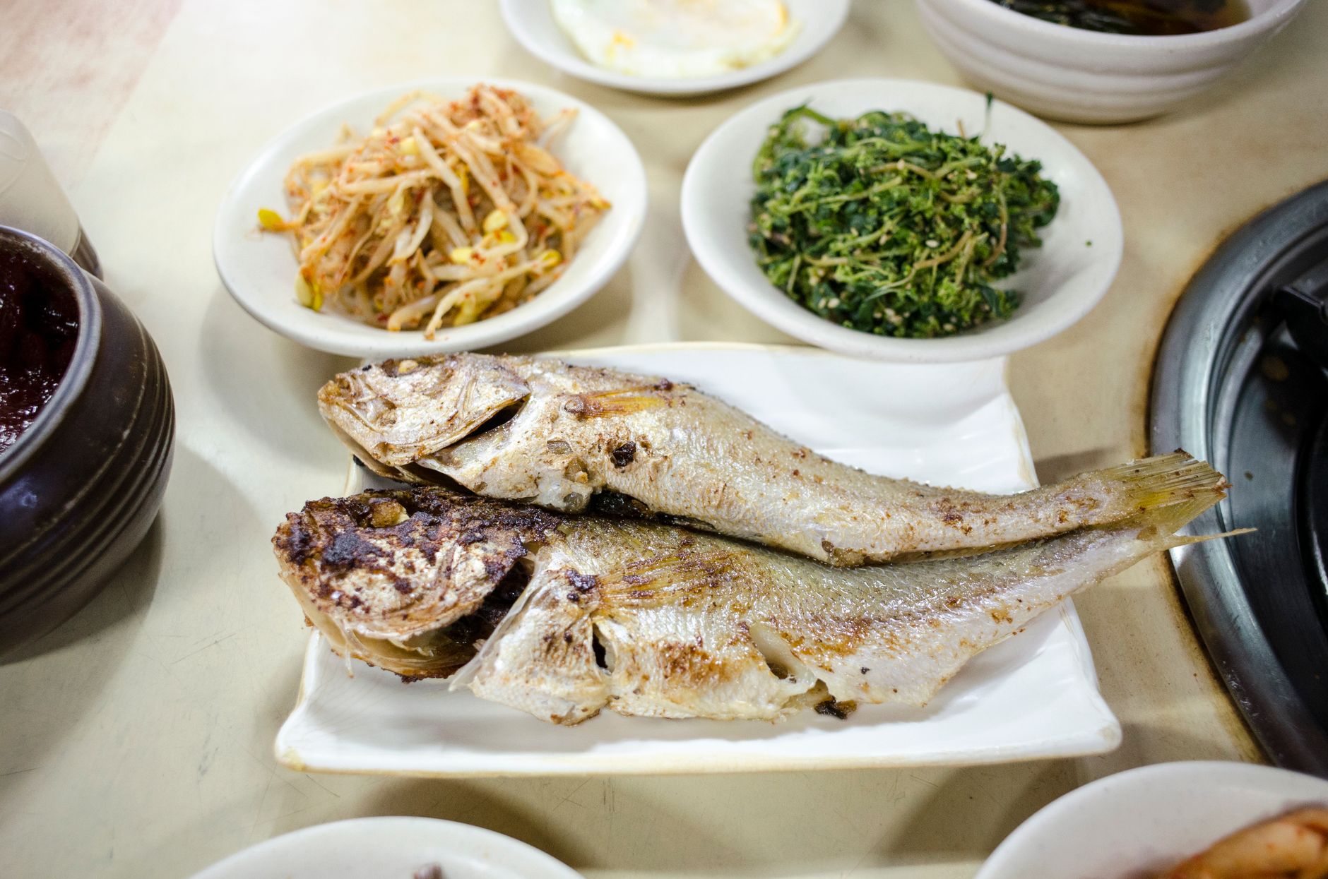 Grilled vegetables beside fish fillet on plate
