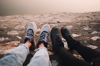 Two Person Wearing Pants and Shoes Sits on Ground at Daytime