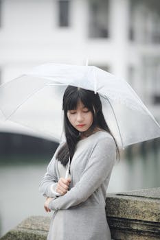 Woman Wearing Gray Sweater Holding Clear Umbrella