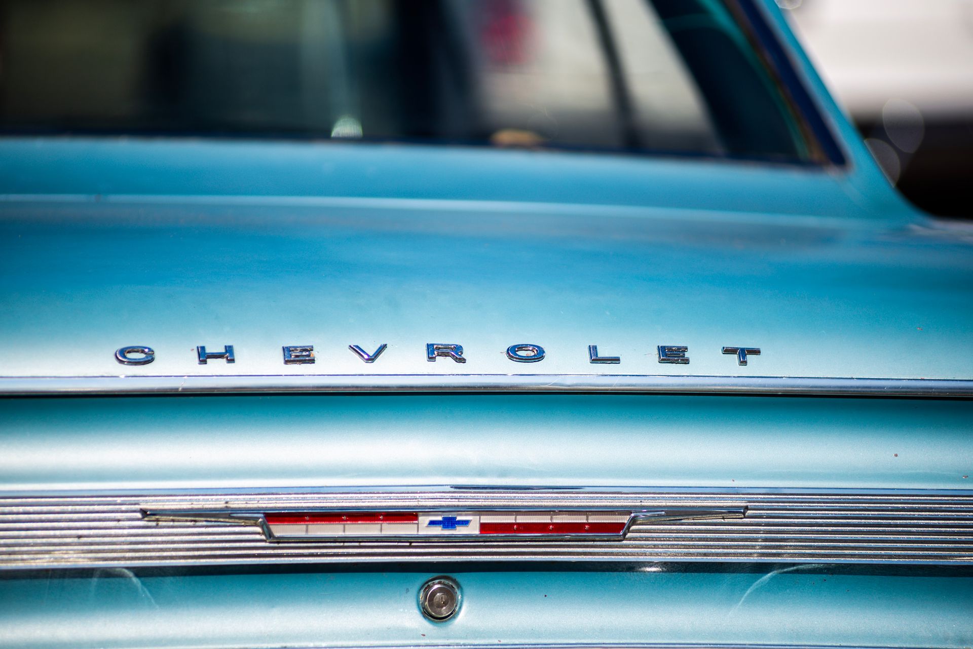 Close-up view of a vintage Chevrolet car trunk showcasing classic design and chrome detailing.