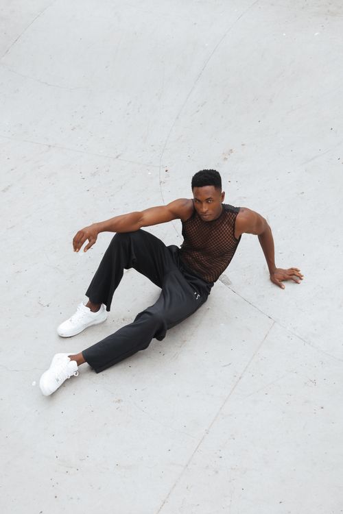 Free A fashionable man poses on a minimalist surface, showcasing modern style in a casual outfit. Stock Photo