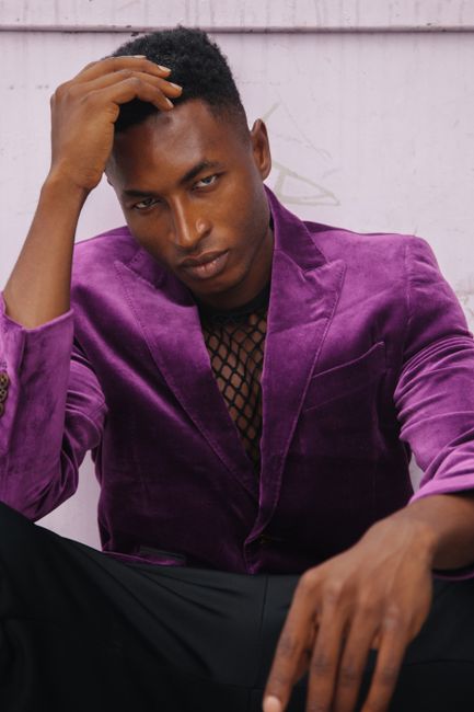 Elegant and stylish portrait of a man in a vibrant purple suit showcasing fashion and attitude.
