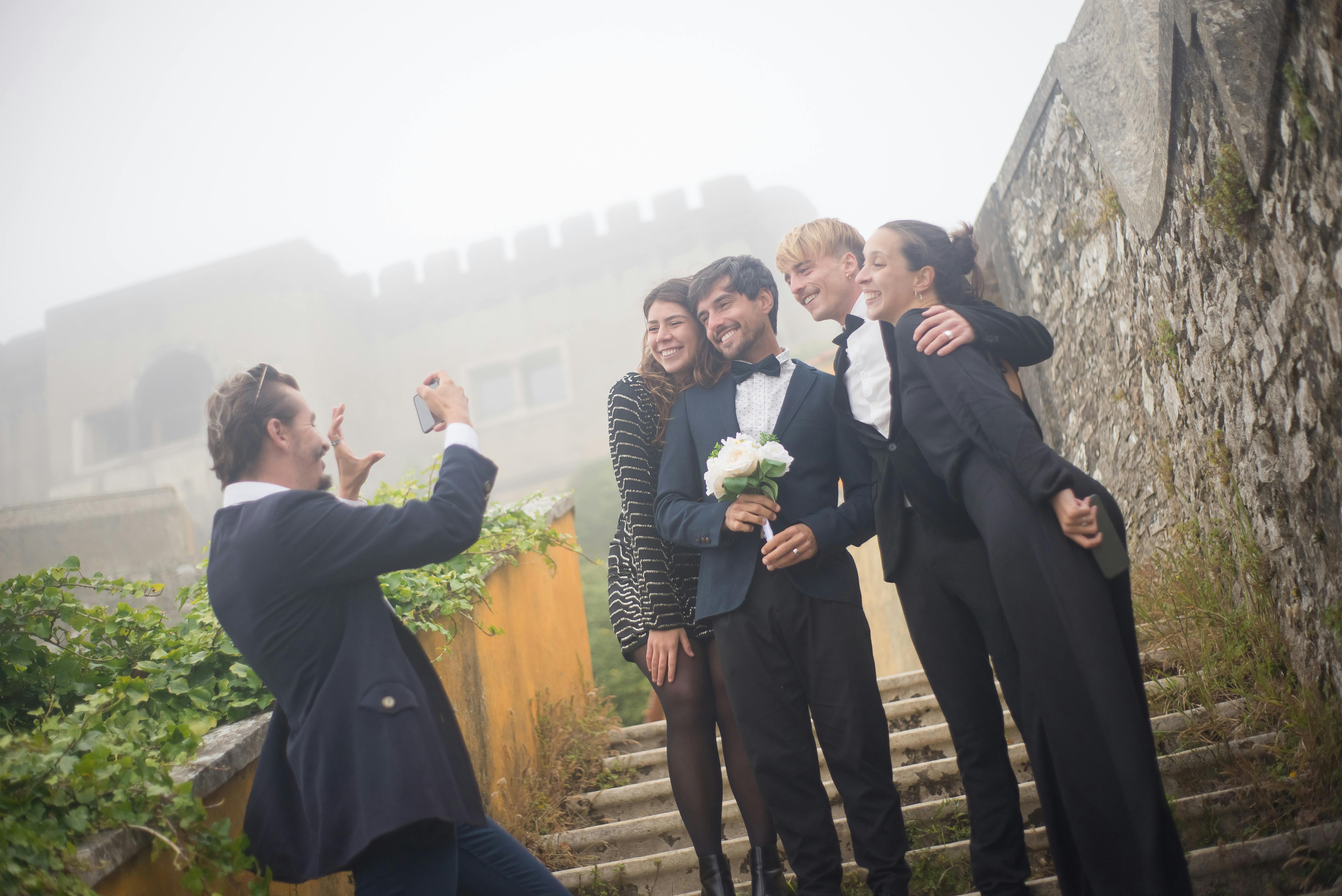 an after the wedding picture taking of a couple with friends