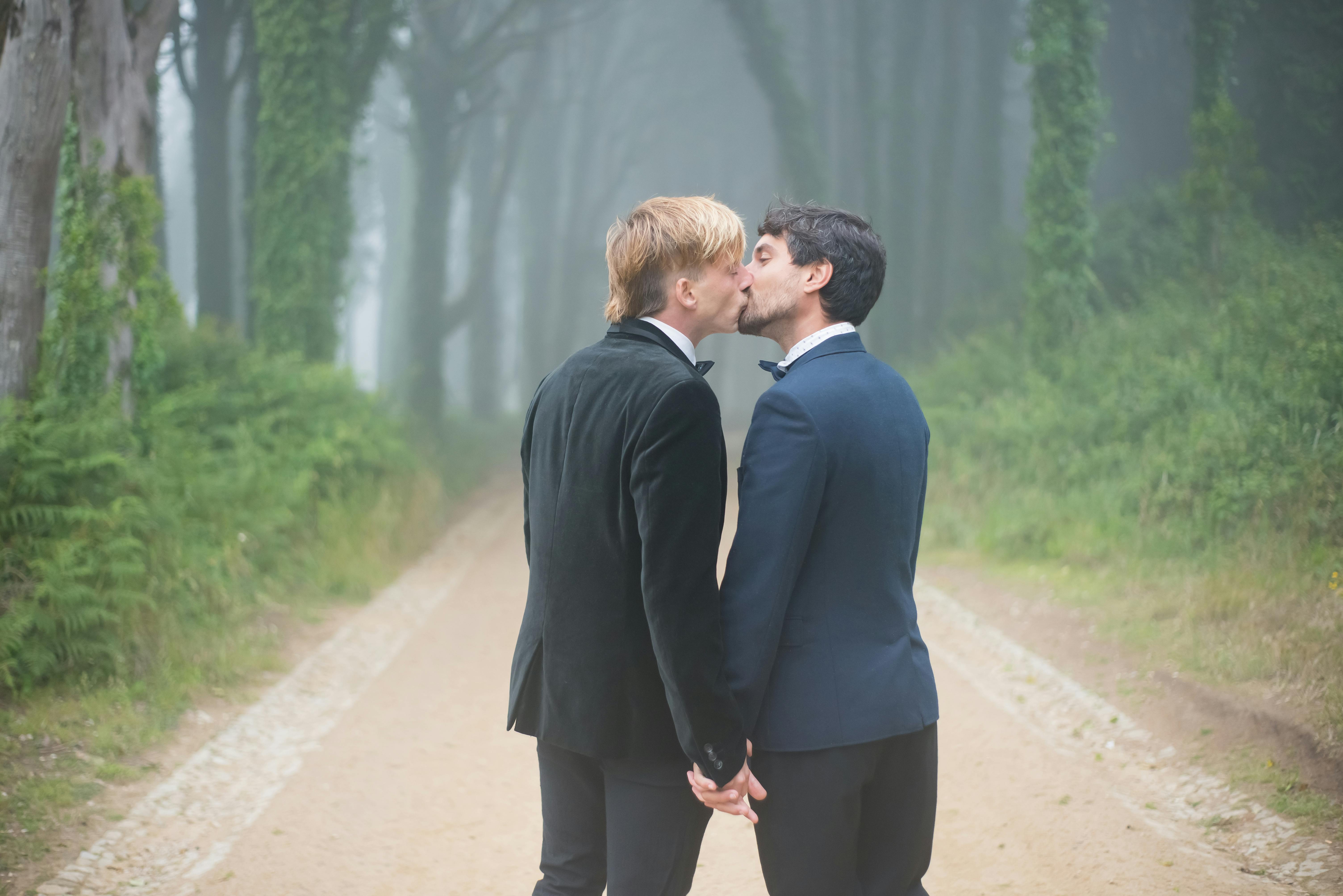 a same sex couple kissing each other while holding hands