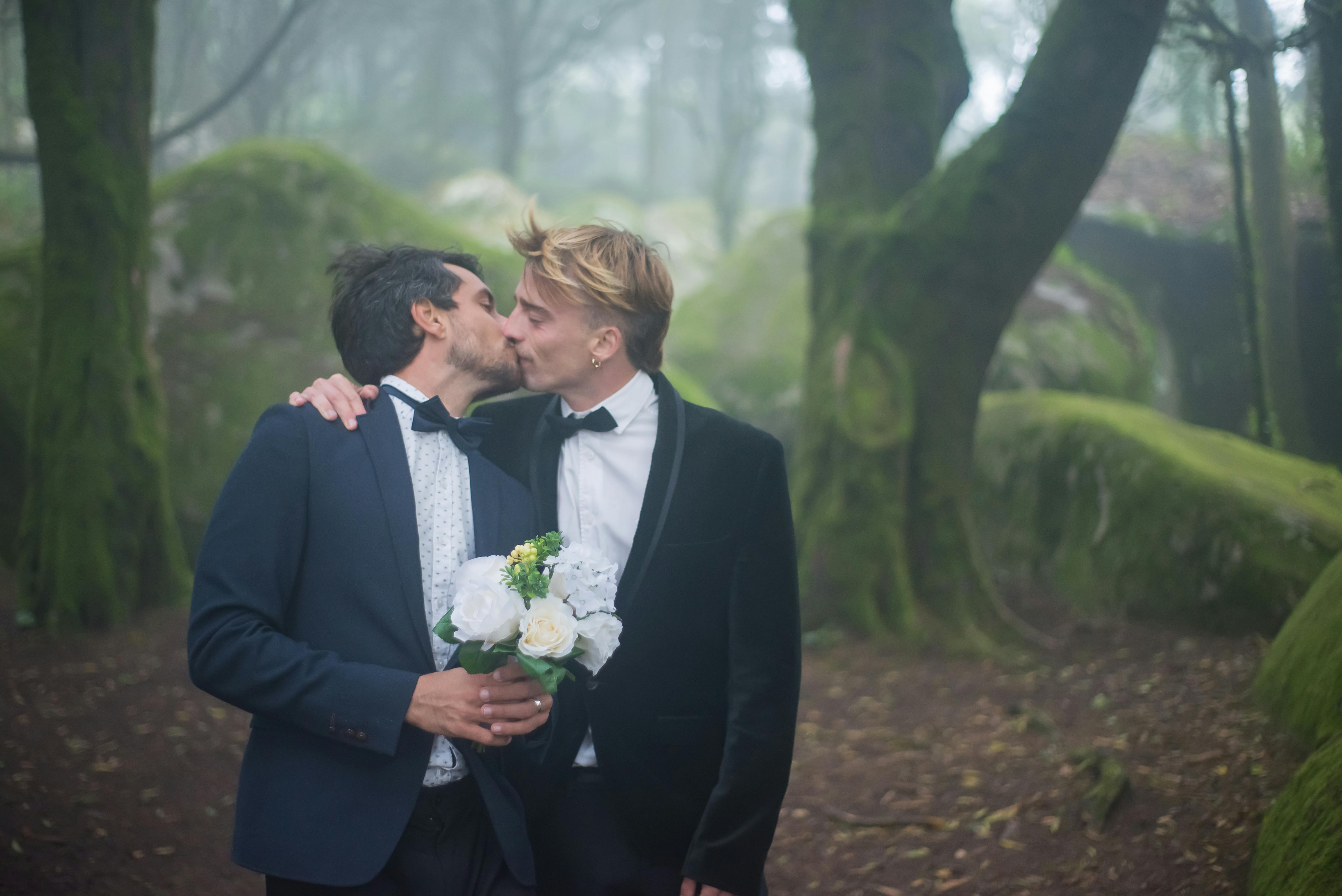 couple kissing wearing black suits