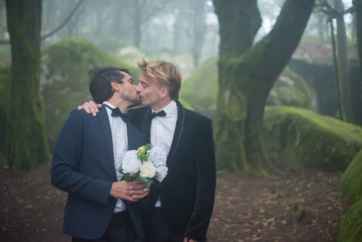 A loving couple shares a romantic kiss amidst a misty, enchanted forest setting.