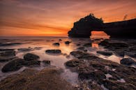 岩石海滩上，充满活力的日出映照着独特的沿海岩石结构