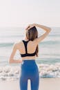Woman in Black Brassiere and Blue Denim Shorts Standing on Beach