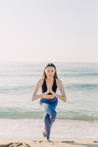 Beautiful Girl Wearing Shorts And Sports Bra In Yoga Pose With Waves  Crashing Over Her Legs On Beach Stock Photo, Picture and Royalty Free  Image. Image 98130965.