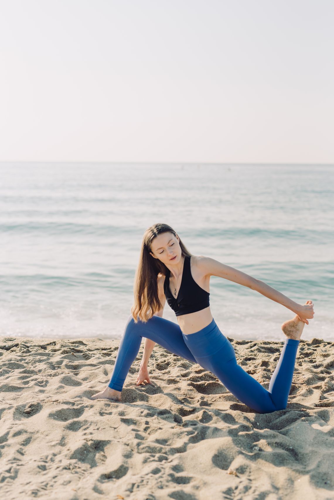 Woman practicing yoga outdoors in activewear