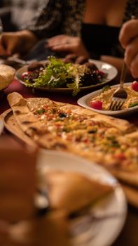 Close-up of traditional Turkish food including pide, hummus, and salad in a restaurant setting.