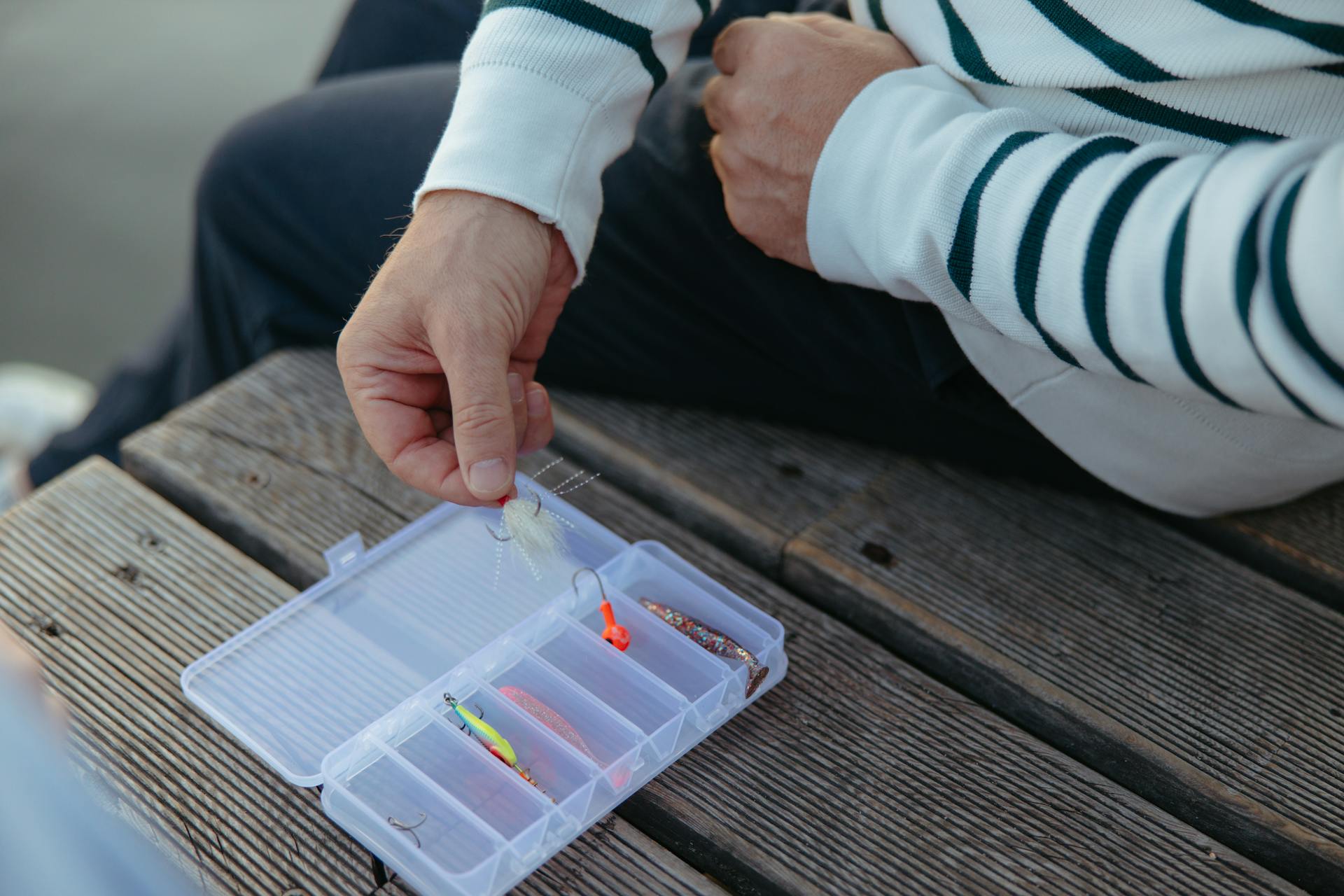 Person Holding Clear Plastic Container With Fishing Tackles