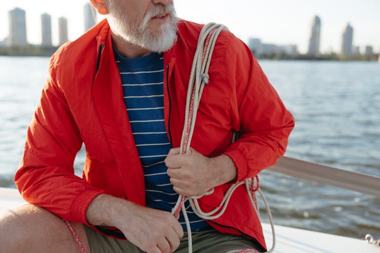 An Elderly Man Holding A Rope While Sailing