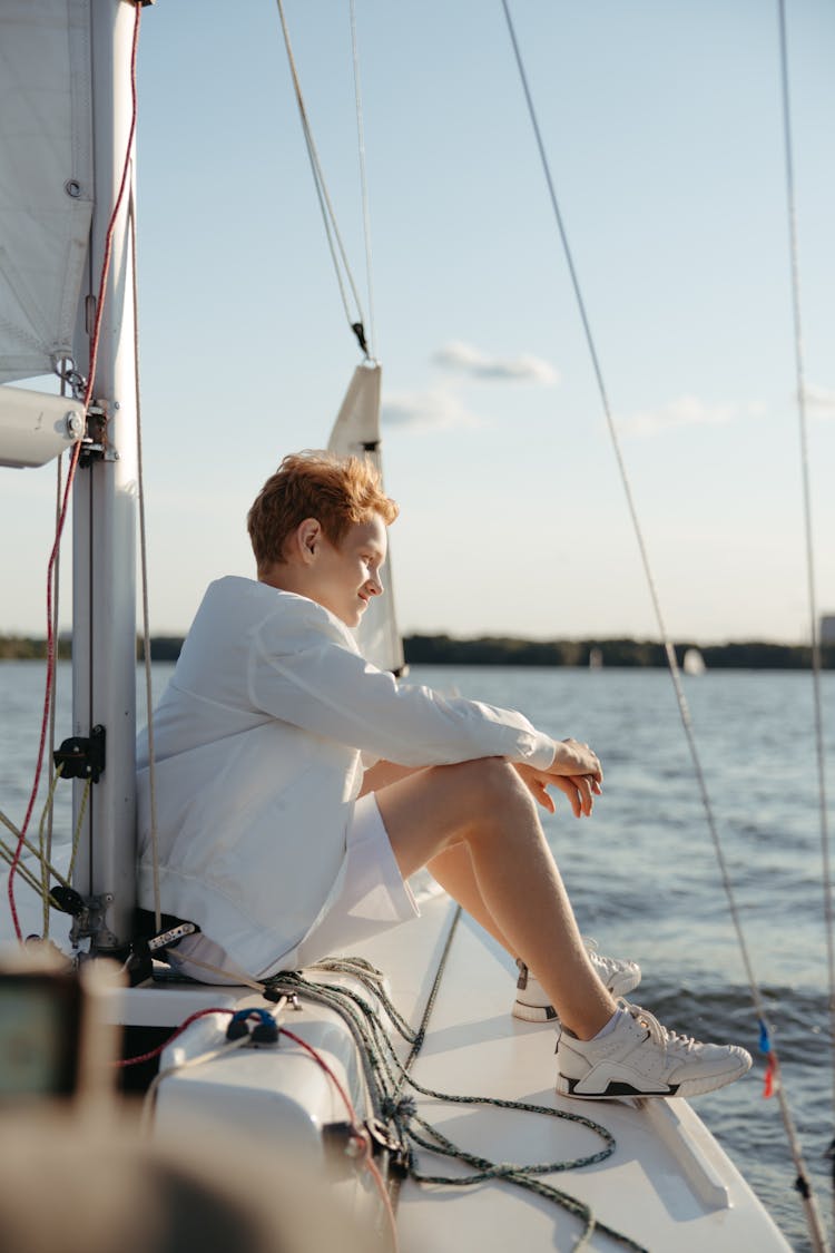 A Young Boy Sitting On A Sailing Boat