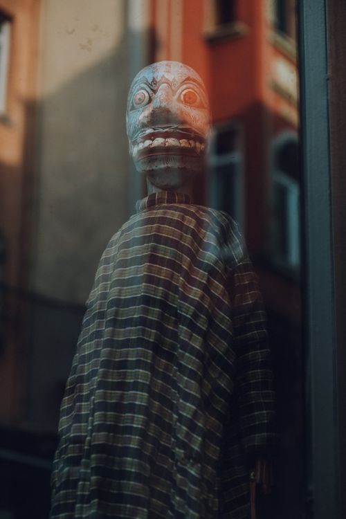 Free A reflection of an eerie mask in a window with atmospheric lighting in Istanbul. Stock Photo