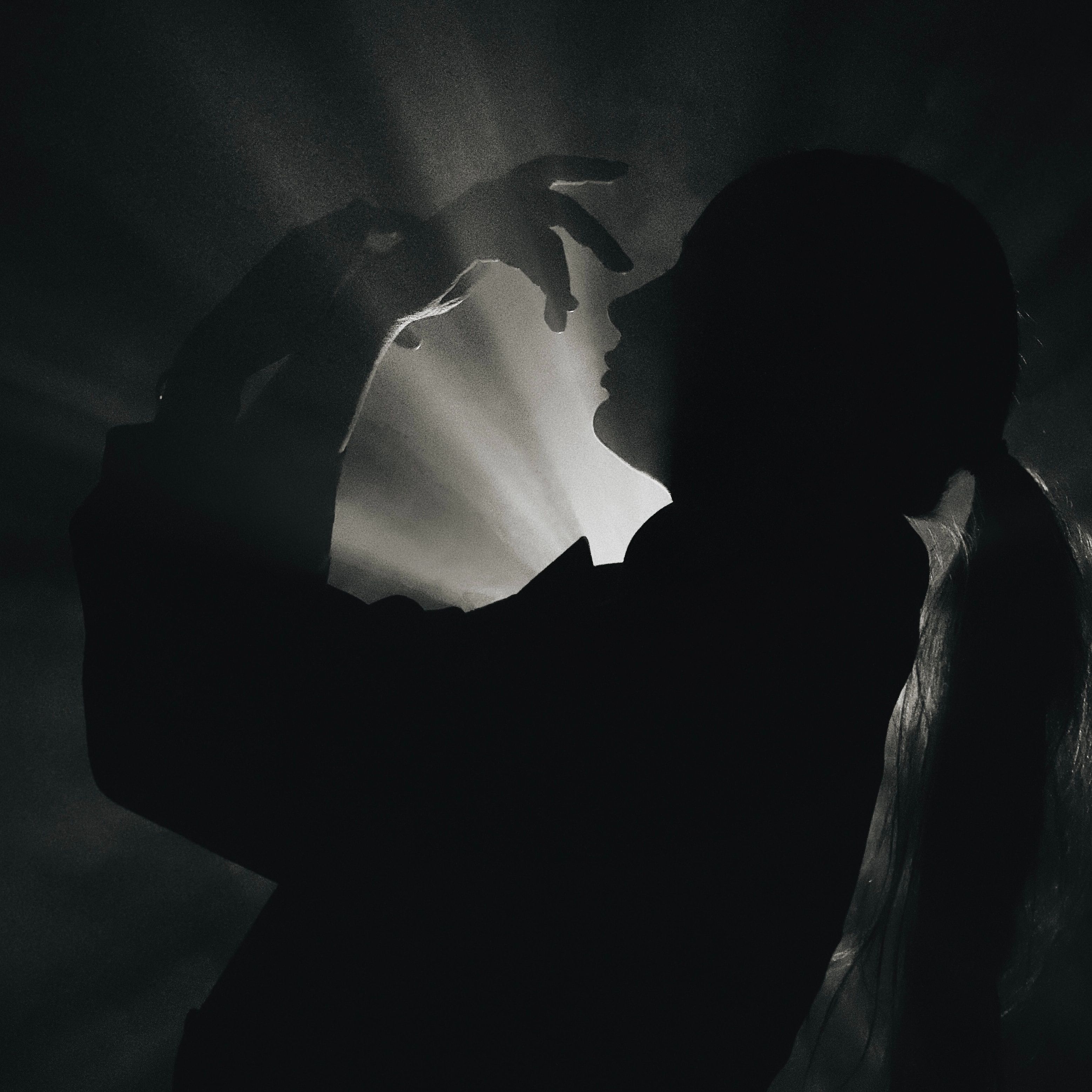 A black and white silhouette of a woman with dramatic light and shadow play.