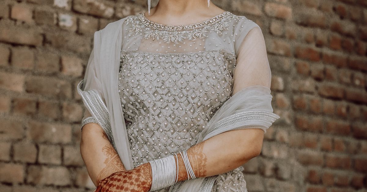 Woman in White Lace Dress Standing Beside Brown Brick Wall · Free Stock ...