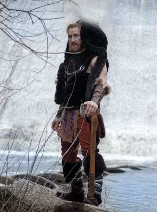 Man in Viking Costume Posing by Lake Shore