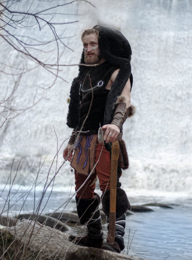 Man In Viking Costume Posing By Lake Shore