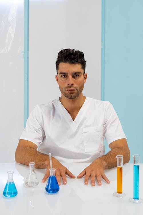 Free Man in White Scrub Suit Behind a Table Stock Photo