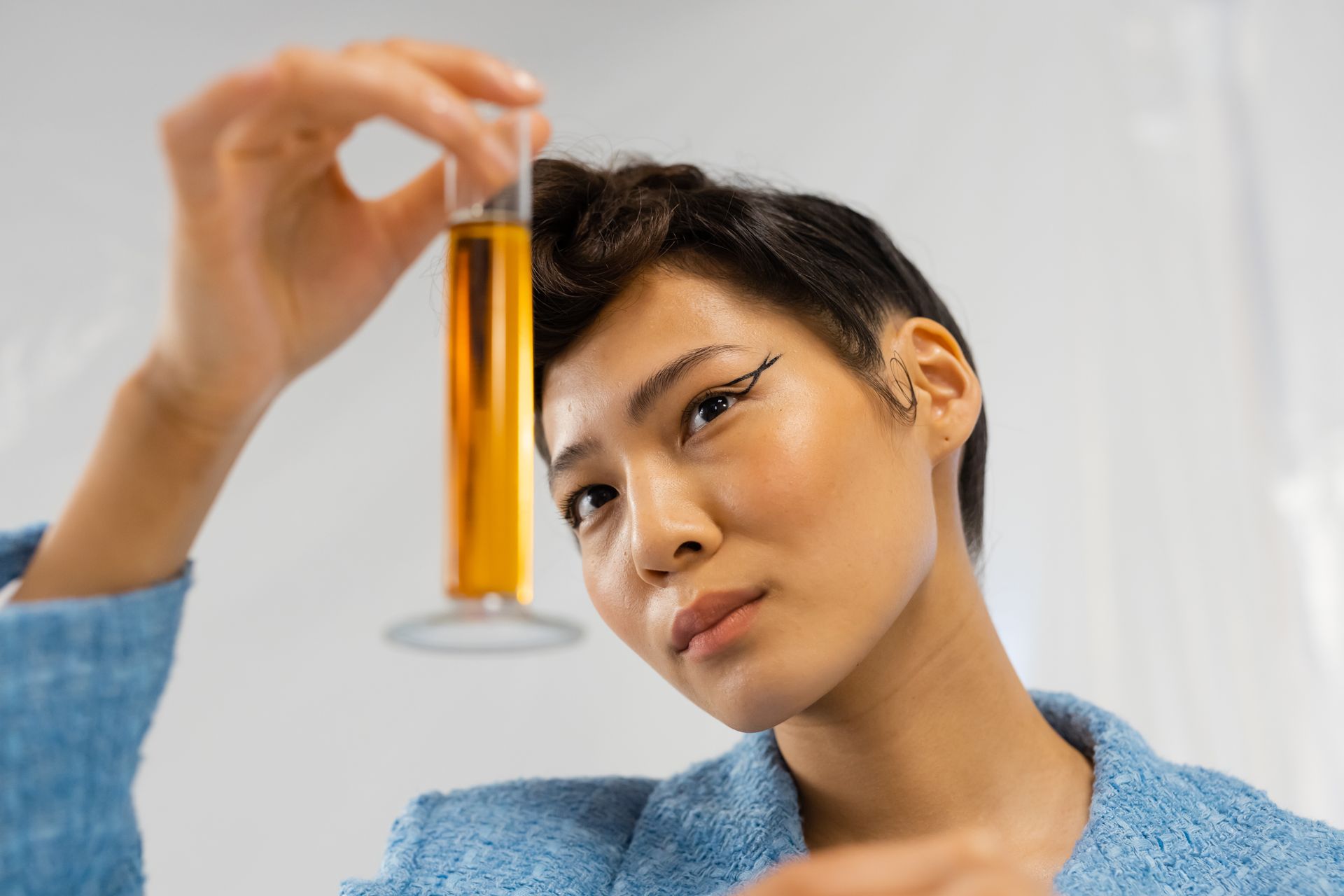 Person Holding a Graduated Cylinder with Yellow Liquid