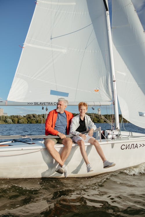 Men Sitting on White Sailboat