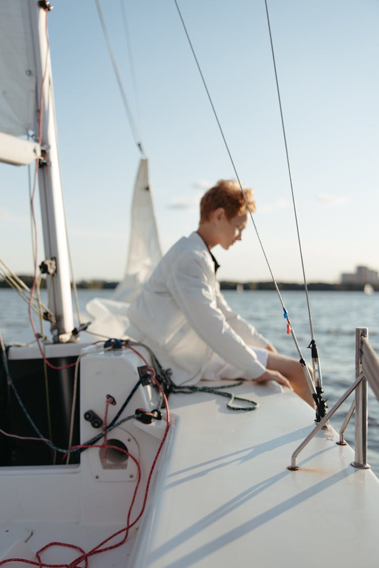 Adolescent Sitting On A Boat Deck 