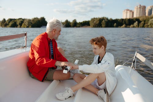 Elderly Man and a Boy Riding on a Boat