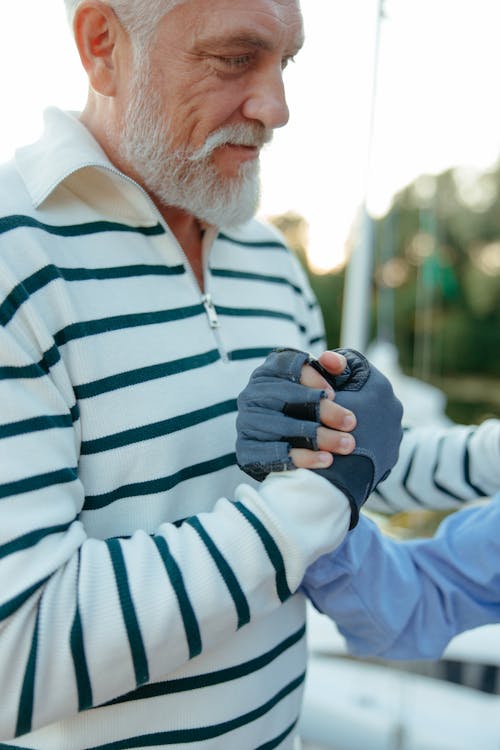 Close up of Elderly Man Holding Hands in Gloves
