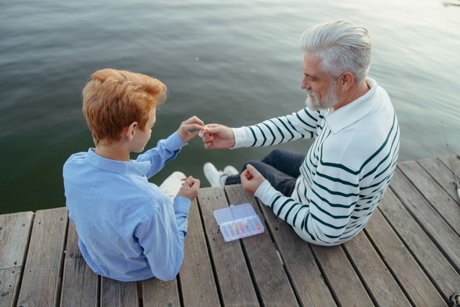 Opa en kleinzoon vissen samen op een houten steiger
