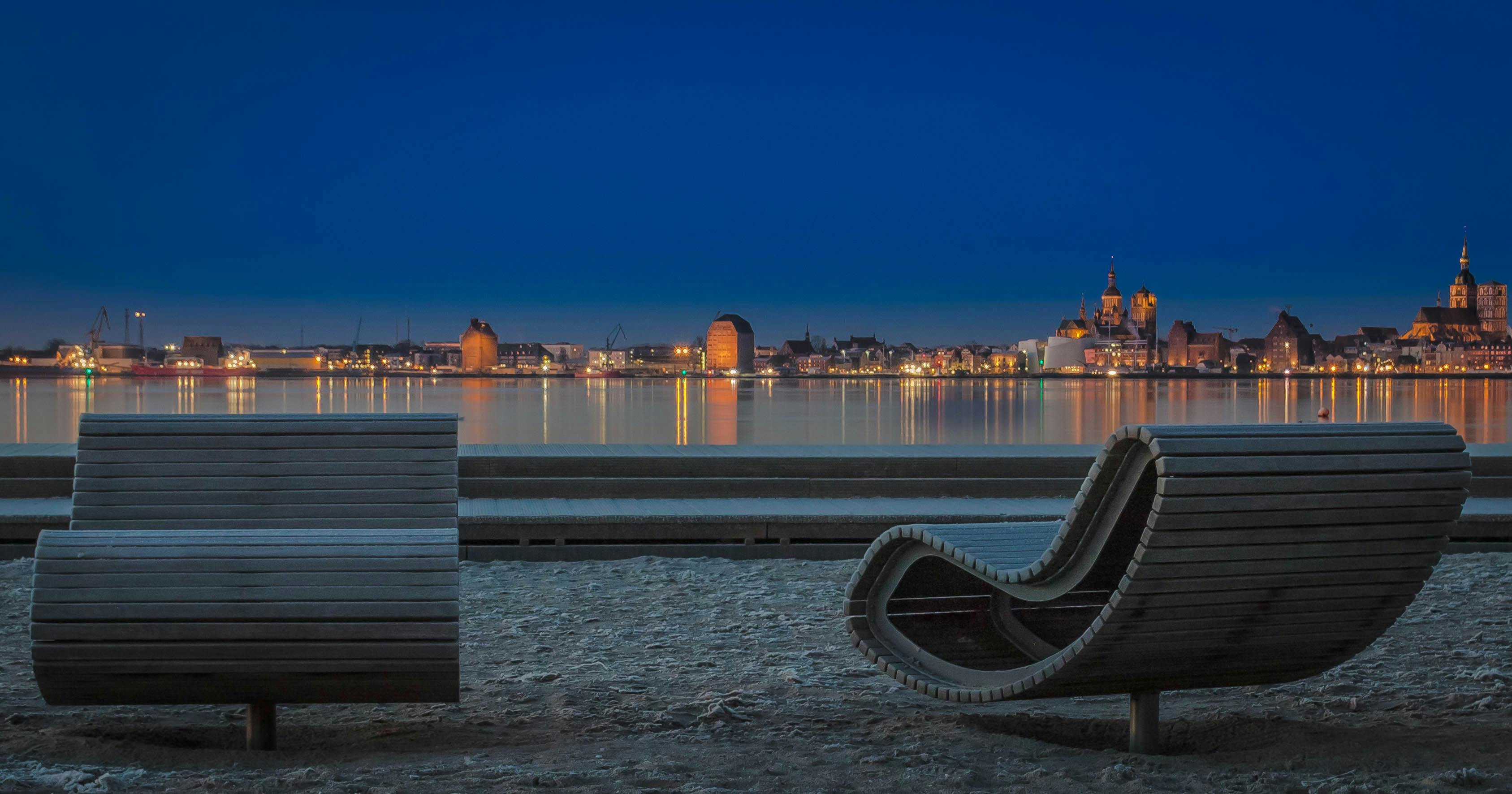 平静的海水中倒映着施特拉尔松德灯火通明的海滨美丽夜色