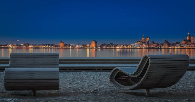 平静的海水中倒映着施特拉尔松德灯火通明的海滨美丽夜色