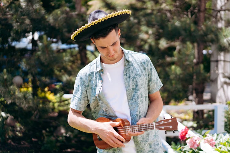 Man In White Shirt And Blue Polo Playing Ukulele 