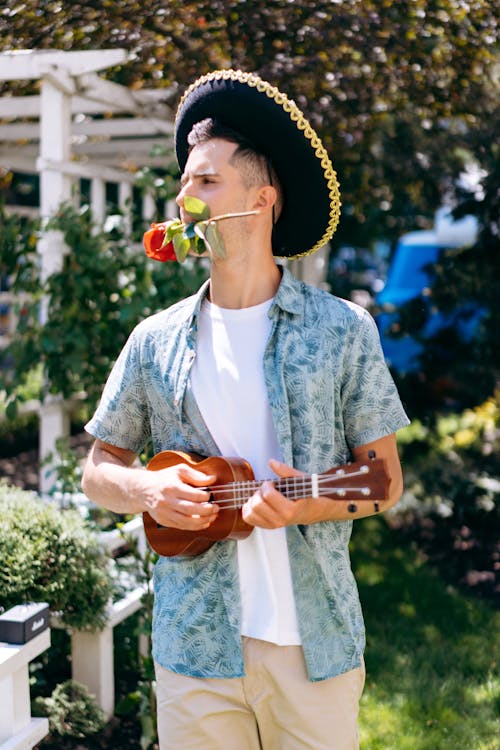 A Man Playing Ukulele with Rose on His Mouth