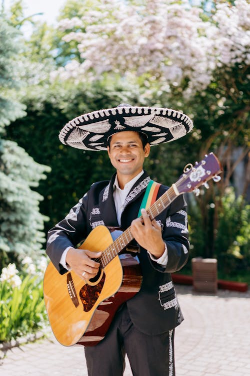 Man In Traditional Mexican Outfit Holding Guitar