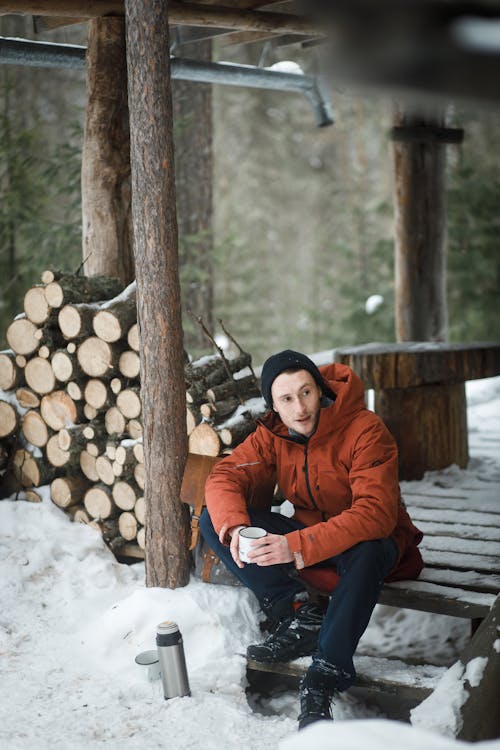 A Man in Winter Jacket Sitting on a Wooden Stairs