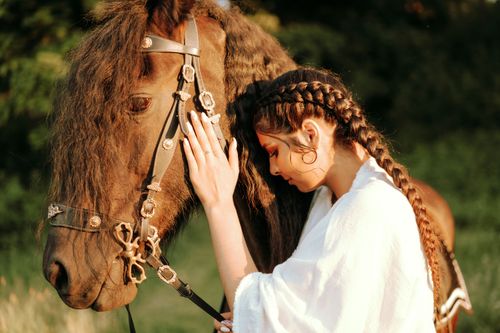 Free A woman in a white blouse gently embraces a horse, showcasing a serene connection. Stock Photo
