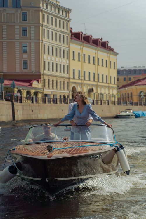 Free A couple enjoys a romantic boat ride along a scenic, historic canal lined with beautiful buildings. Stock Photo