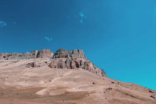 Crisp landscape view of a rugged mountain range beneath a vivid blue sky.