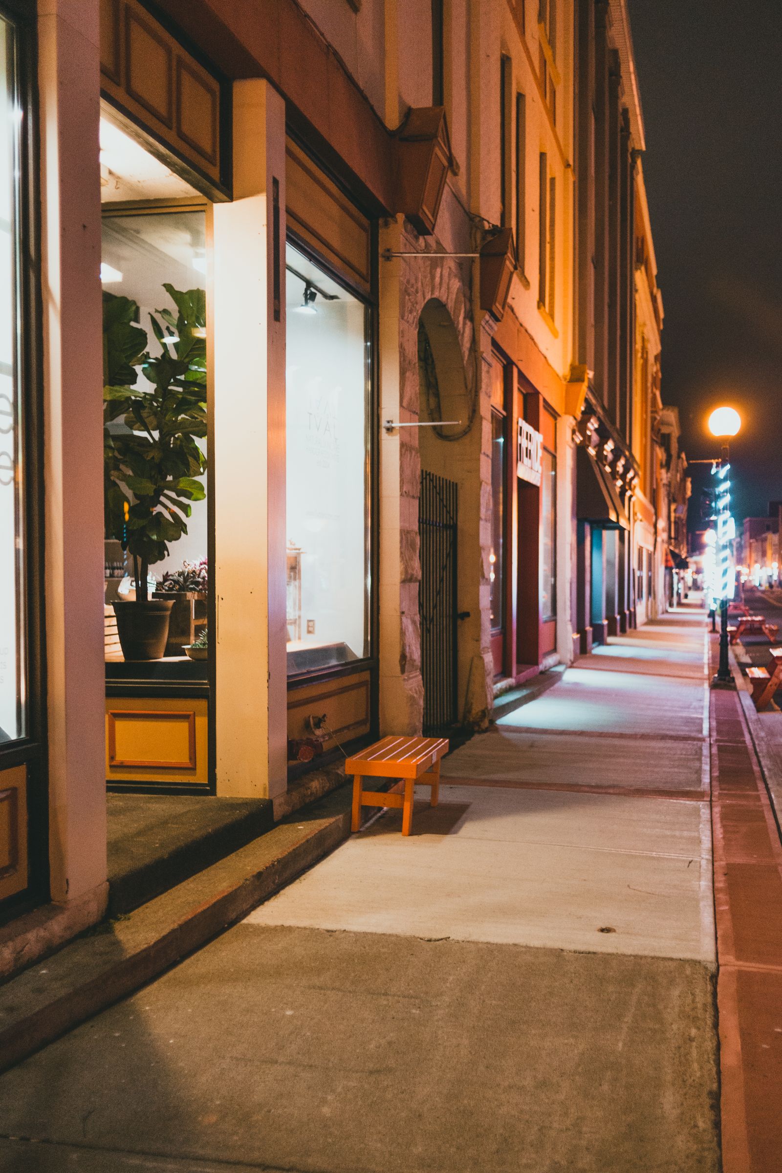 Storefronts on a main street at night.